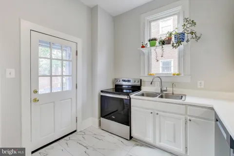 a kitchen with white cabinets appliances and sink