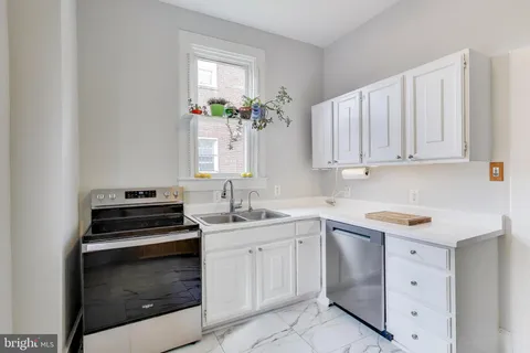 a kitchen with stainless steel appliances a refrigerator sink and cabinets