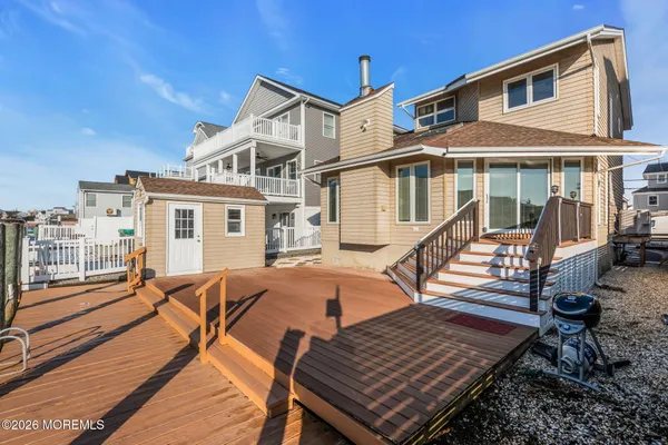 a view of a house with wooden deck and furniture
