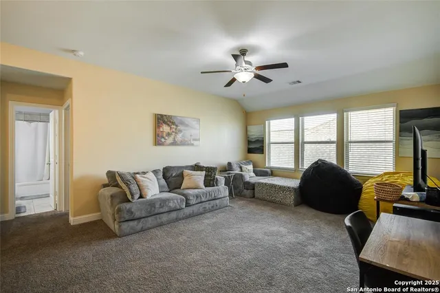a living room with furniture and a ceiling fan