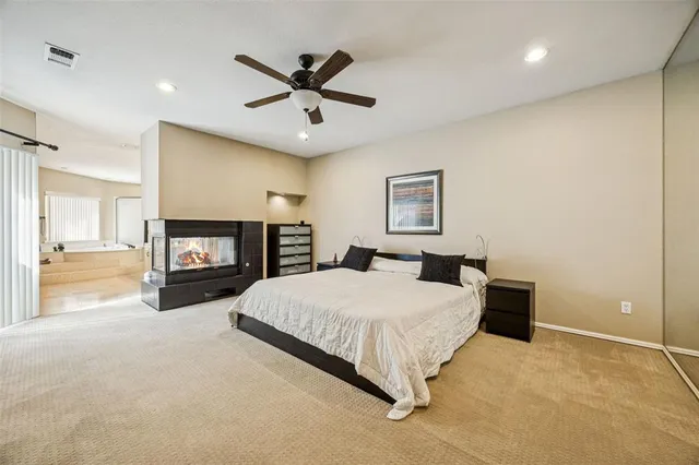 a bedroom with a large bed and a fireplace