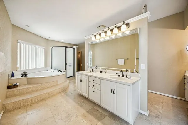 a spacious bathroom with a tub sink and mirror