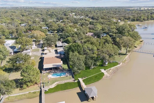 an aerial view of a house with a yard and lake view