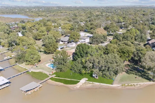 an aerial view of a house with a yard and greenery