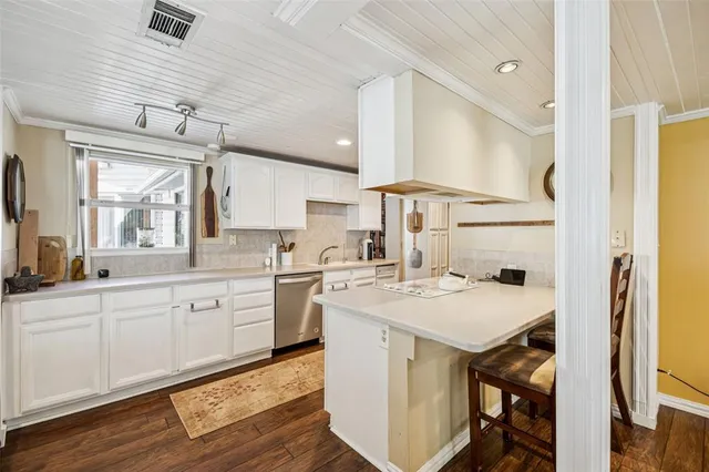 a kitchen with white cabinets stove and sink