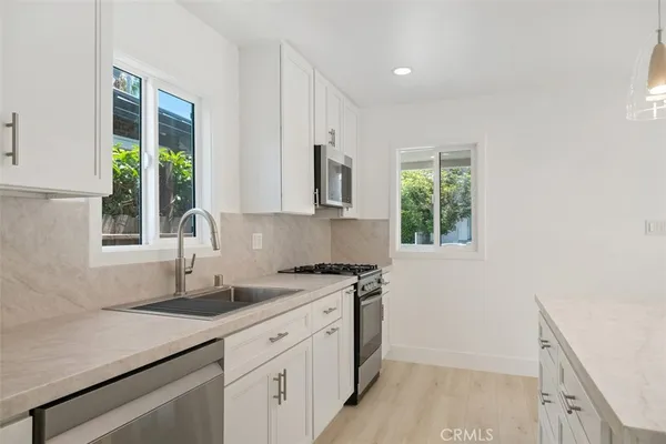 a kitchen with a sink a window and cabinets