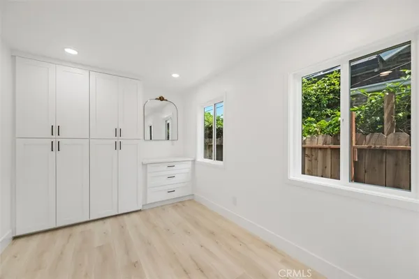 an empty room with windows and cabinet