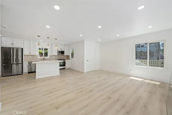 a view of kitchen with kitchen island a sink stainless steel appliances and cabinets