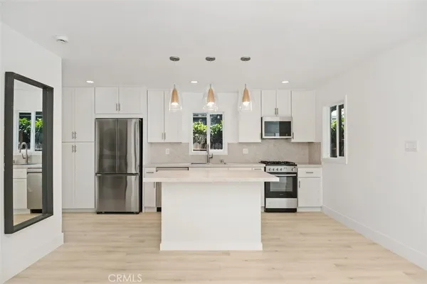 a kitchen with stainless steel appliances a refrigerator sink and stove