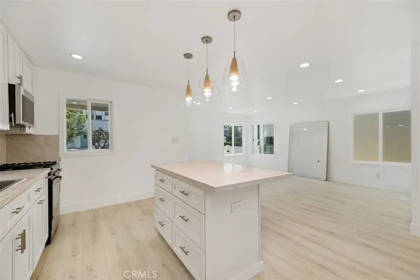 a kitchen with stainless steel appliances granite countertop a sink and a stove with wooden floor