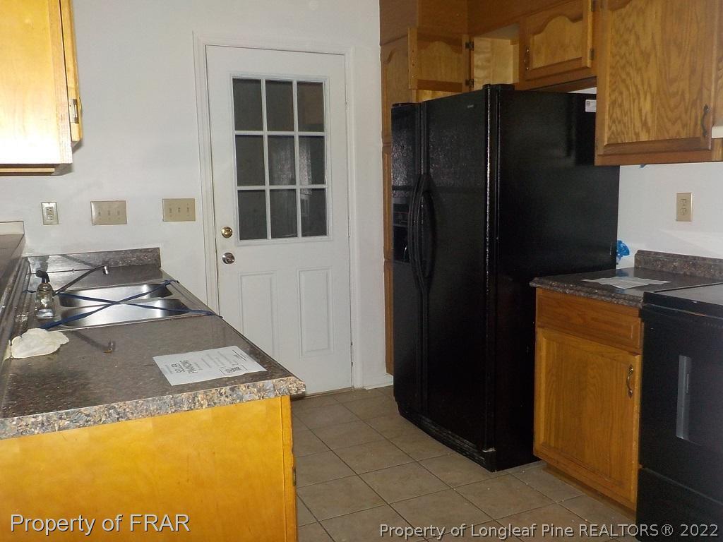 6598 Applewhite Road Fayetteville, NC 28304 - Photo 2 of 9 a kitchen with a refrigerator and a stove