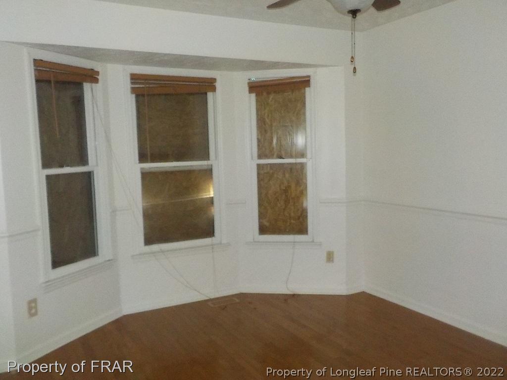 6598 Applewhite Road Fayetteville, NC 28304 - Photo 4 of 9 a view of an empty room with window and wooden floor
