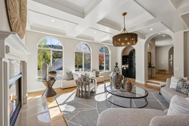 a kitchen with stainless steel appliances granite countertop a stove top oven a sink dishwasher and white cabinets with wooden floor