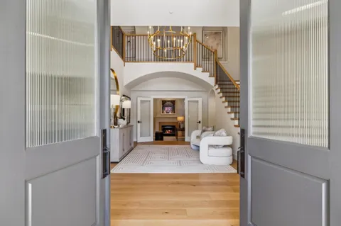 a living room with furniture a fireplace and a chandelier
