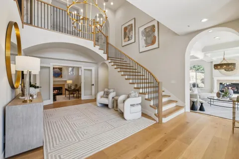 a living room with furniture a fireplace and a chandelier
