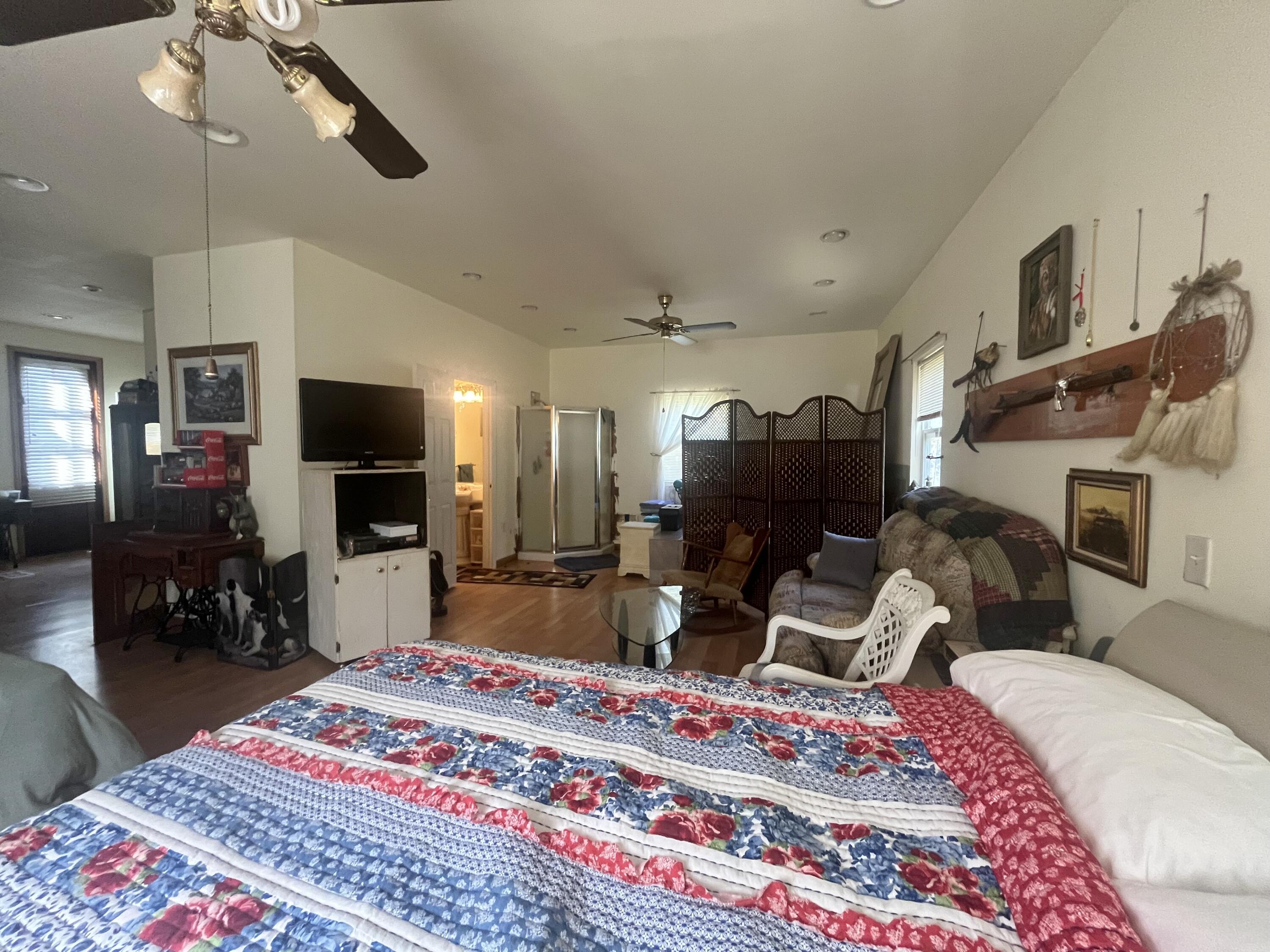 58 Hankins Road Freeport, FL 32439 - Photo 17 of 29 a bedroom with a bed a mirror on dresser and a flat screen tv