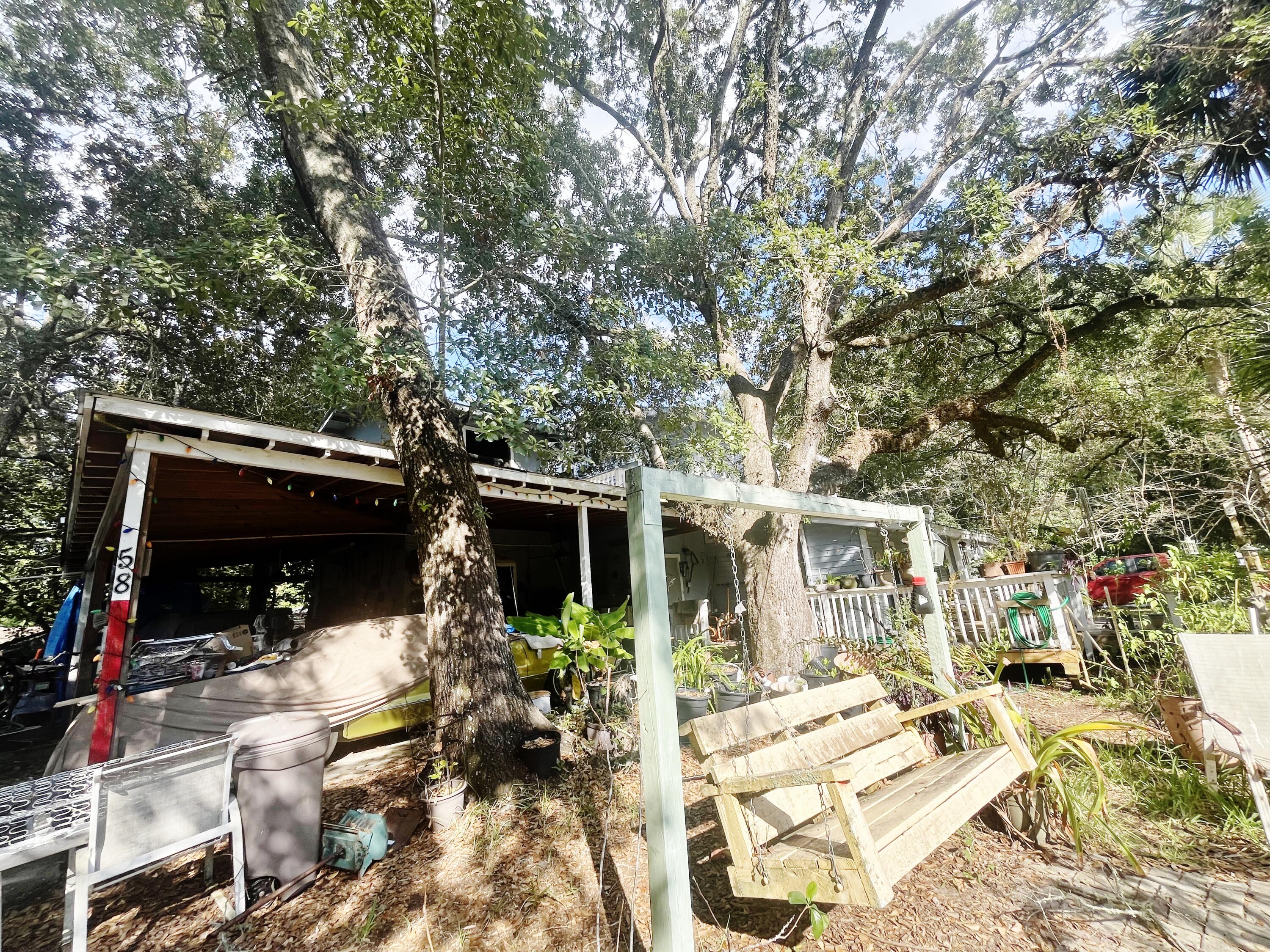 58 Hankins Road Freeport, FL 32439 - Photo 23 of 29 a view of house with patio outdoor seating and covered with trees