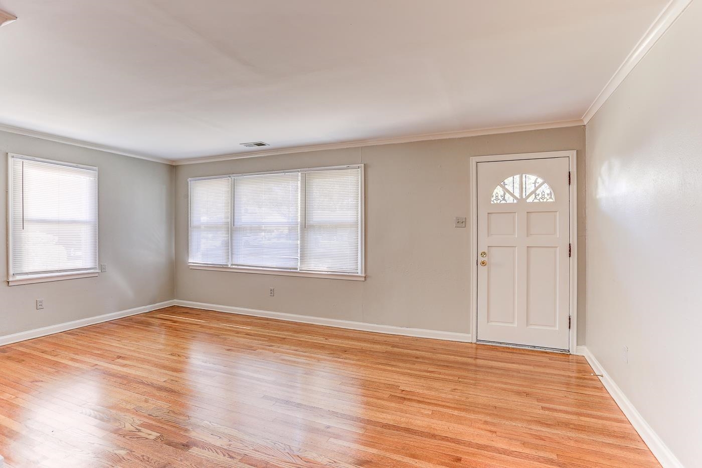1369 Marcia Road Memphis, TN 38117 - Photo 4 of 25 a view of an empty room with wooden floor and a window