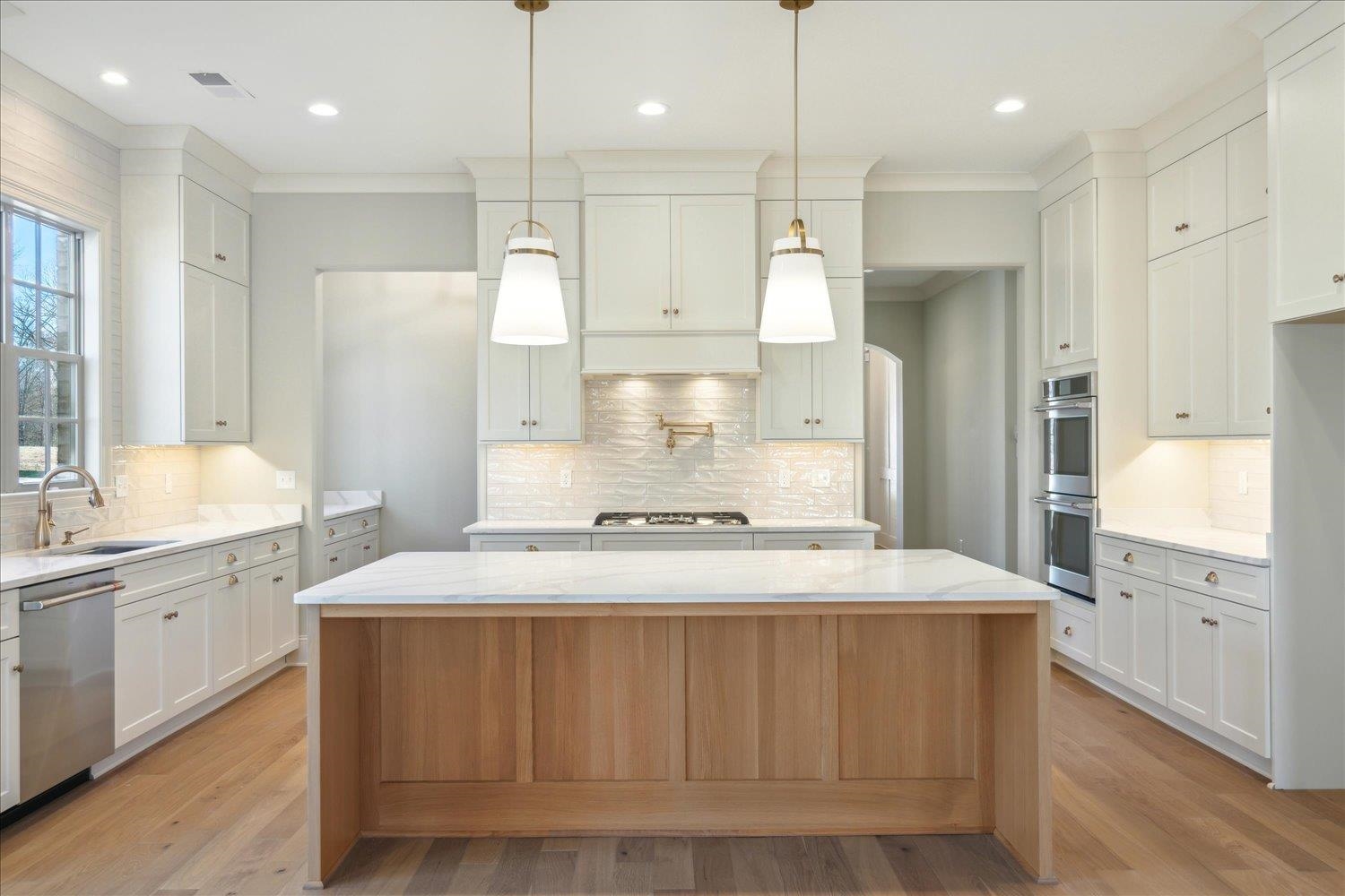 12620 Miss Cloud Road Collierville, TN 38017 - Photo 11 of 38 Kitchen featuring a kitchen island, stainless steel appliances, and white cabinetry