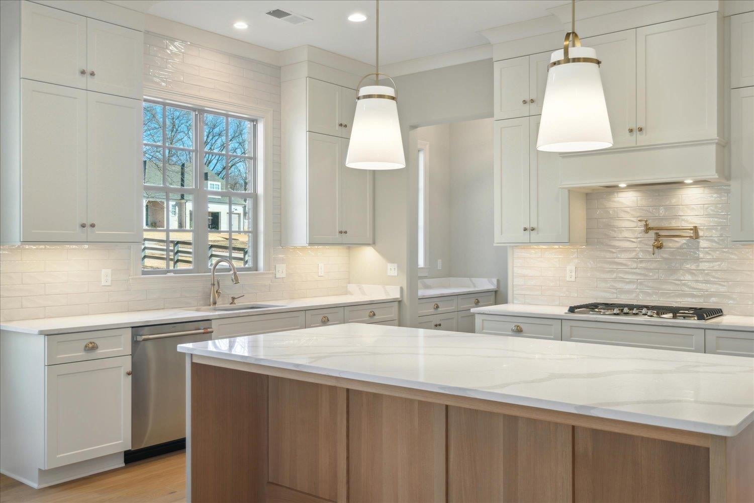 12620 Miss Cloud Road Collierville, TN 38017 - Photo 12 of 38 Kitchen featuring light stone counters, white cabinets, and appliances with stainless steel finishes