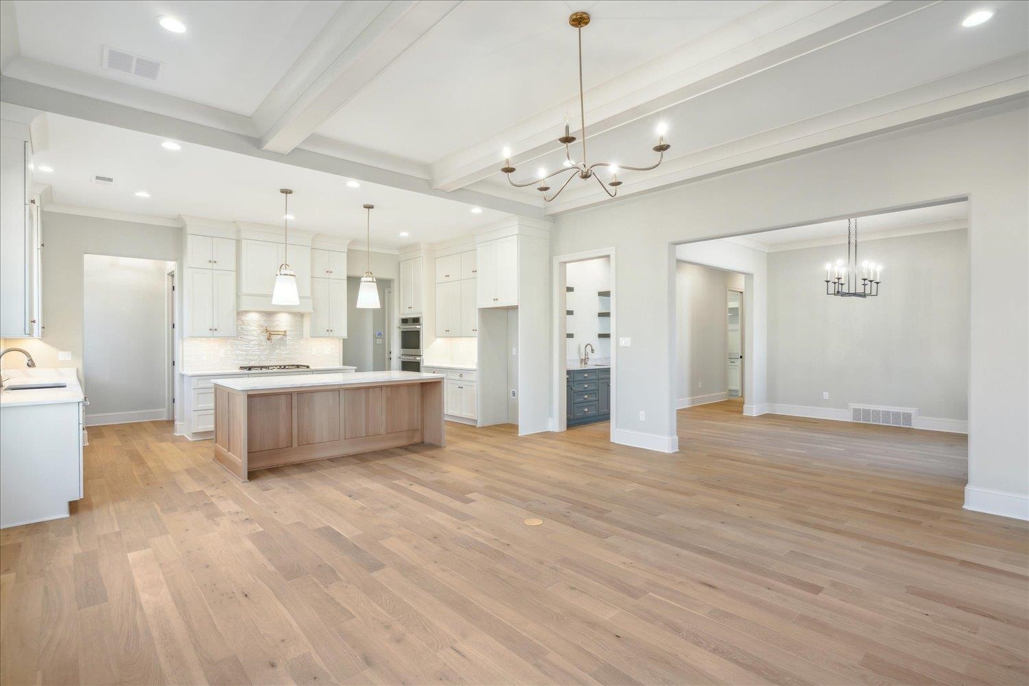 12620 Miss Cloud Road Collierville, TN 38017 - Photo 10 of 38 Kitchen featuring white cabinets, sink, beamed ceiling, and a spacious island