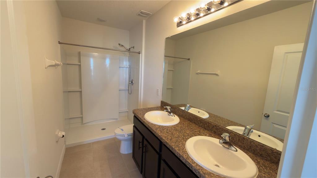 1881 Hovenweep Road Wesley Chapel, FL 33543 - Photo 14 of 18 a bathroom with a granite countertop sink toilet a mirror and shower
