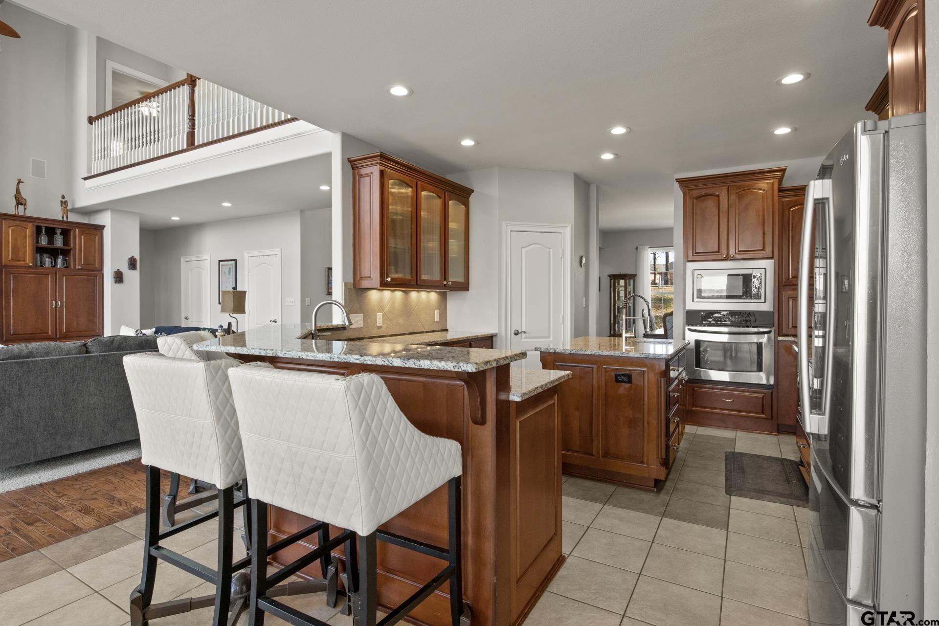 59 Private Road Pittsburg, TX 75686 - Photo 13 of 45 a dining hall with stainless steel appliances granite countertop a table chairs and a refrigerator