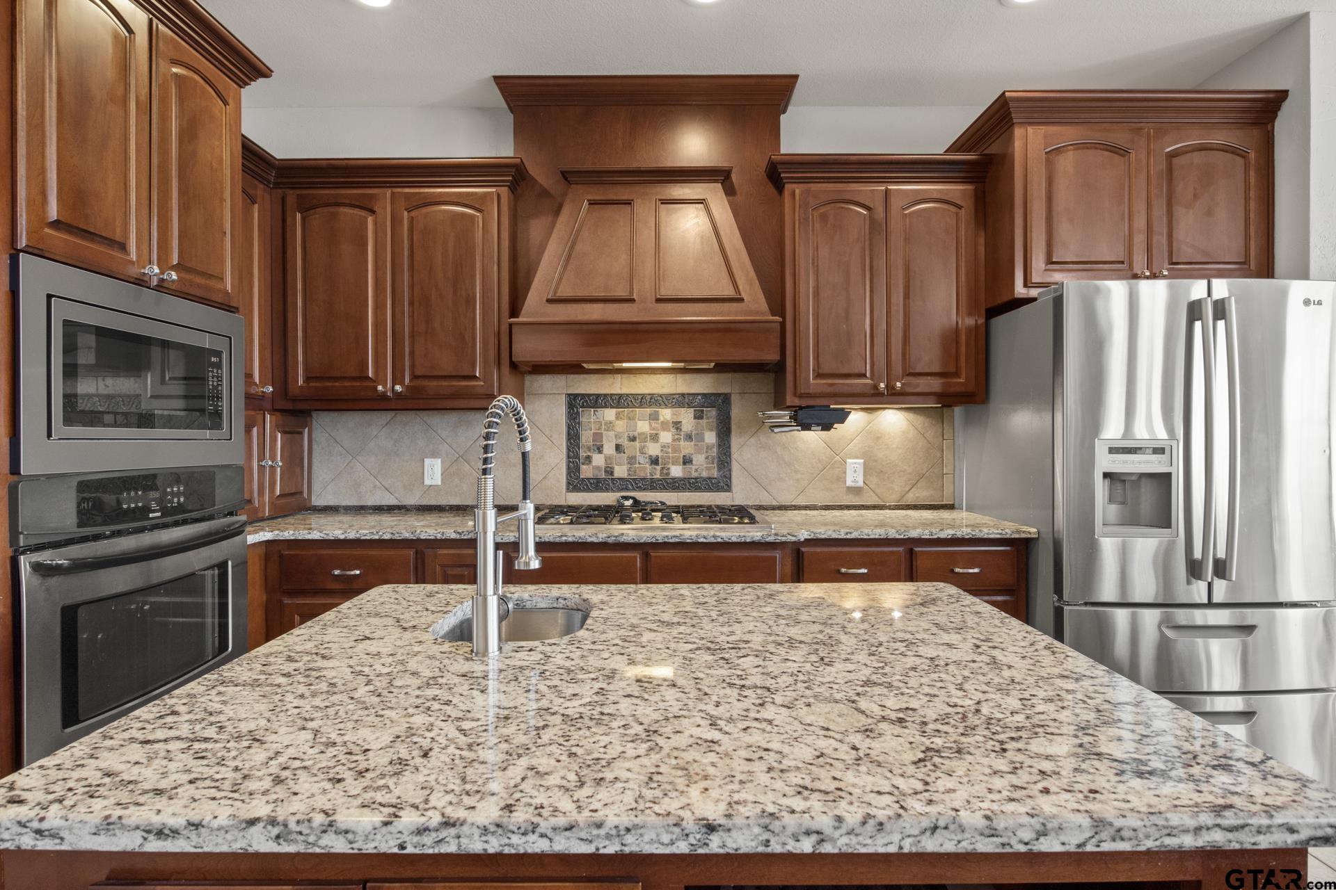 59 Private Road Pittsburg, TX 75686 - Photo 17 of 45 a kitchen with kitchen island granite countertop a stove refrigerator and microwave
