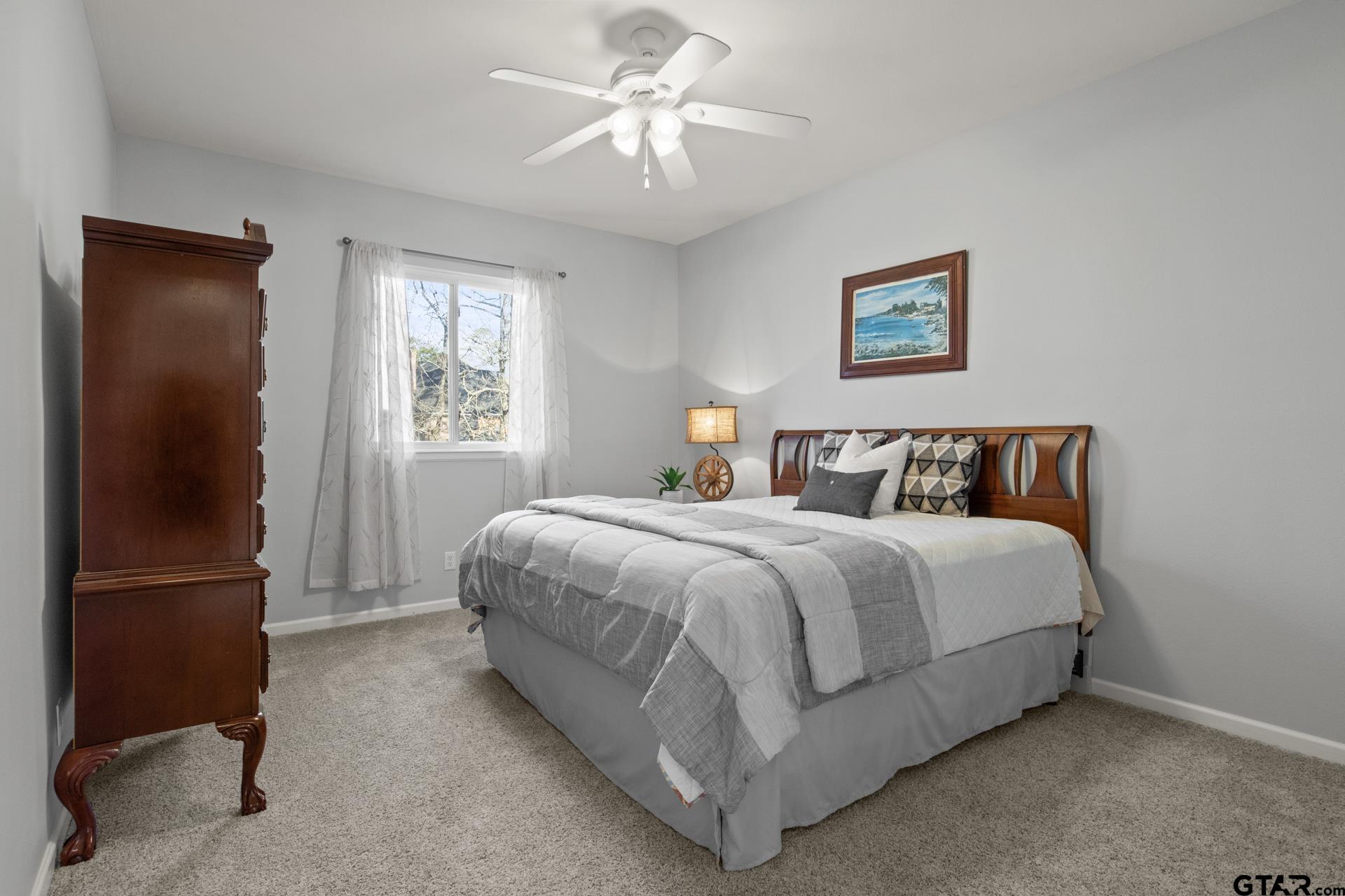 59 Private Road Pittsburg, TX 75686 - Photo 32 of 45 a spacious bedroom with a bed and a chandelier