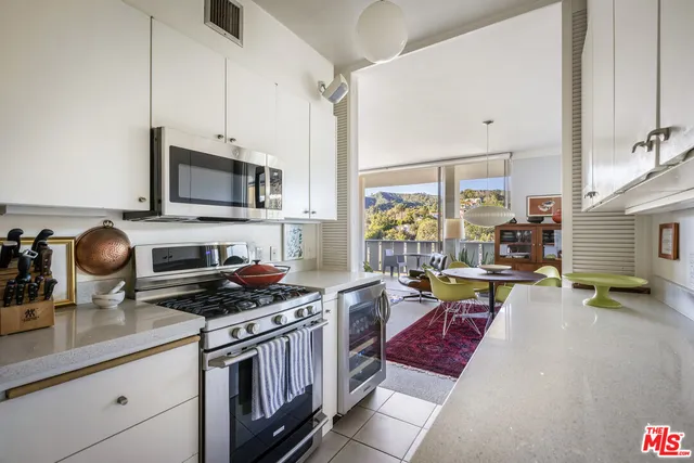 a kitchen with stainless steel appliances granite countertop a stove a sink and a white cabinets