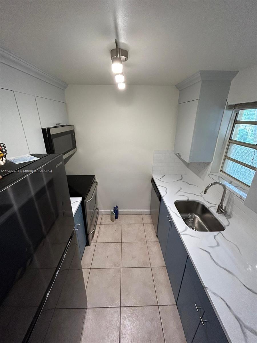 8550 Southwest 109th Avenue, Unit 5119 Miami, FL 33173 - Photo 5 of 14 a kitchen with a sink and a stove top oven