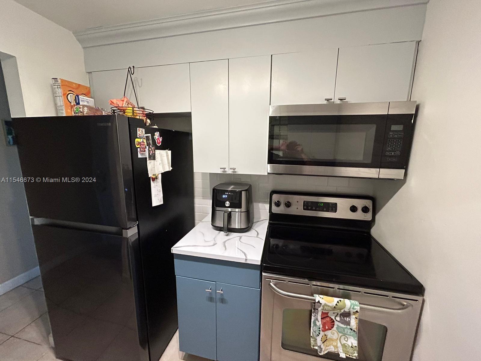8550 Southwest 109th Avenue, Unit 5119 Miami, FL 33173 - Photo 6 of 14 a kitchen with stainless steel appliances a refrigerator a stove and cabinets