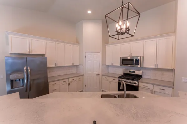 a kitchen with stainless steel appliances a refrigerator and microwave