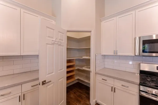 a kitchen with white cabinets and appliances