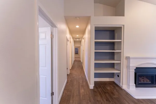 a view of a hallway with wooden floor and a fireplace