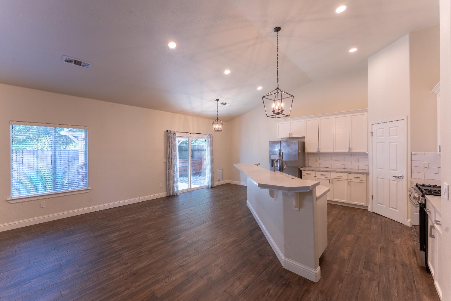 1963 Rialto Court Clovis, CA 93611 - Photo 9 of 36 a open kitchen with kitchen island white cabinets and wooden floor