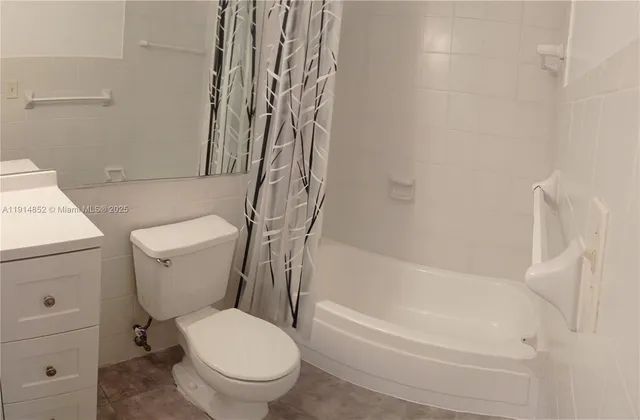 a white toilet sitting next to a bath tub