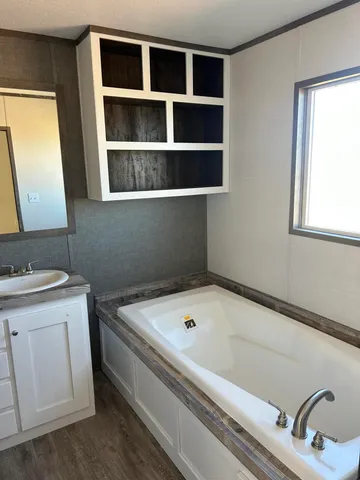 a bathroom with a tub sink and mirror