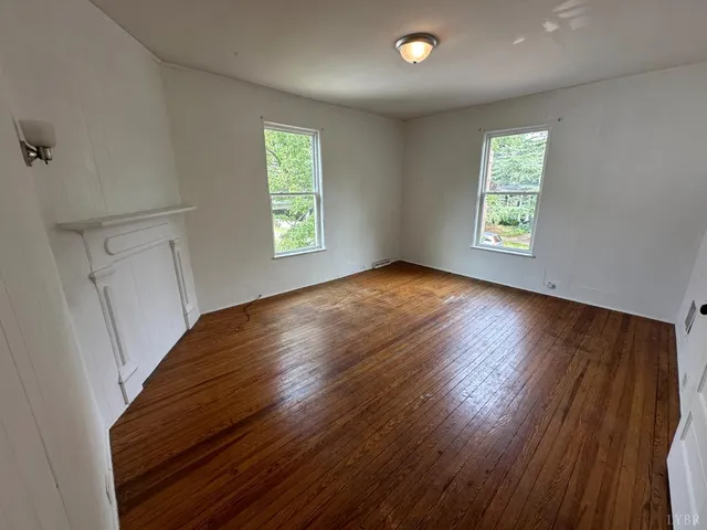 an empty room with windows and cabinet
