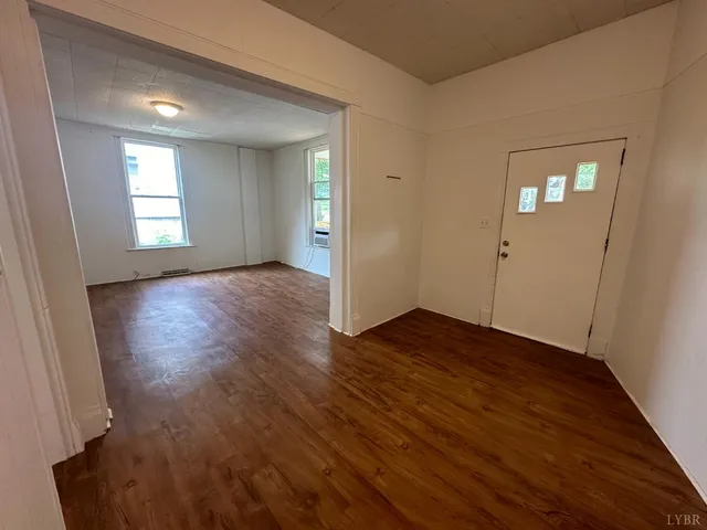 an empty room with wooden floor and mirror