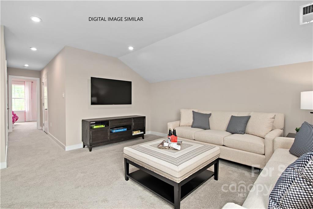 1619 Moore Farm Road, Unit 184 Indian Trail, NC 28079 - Photo 21 of 28 a living room with furniture a flat screen tv and a table