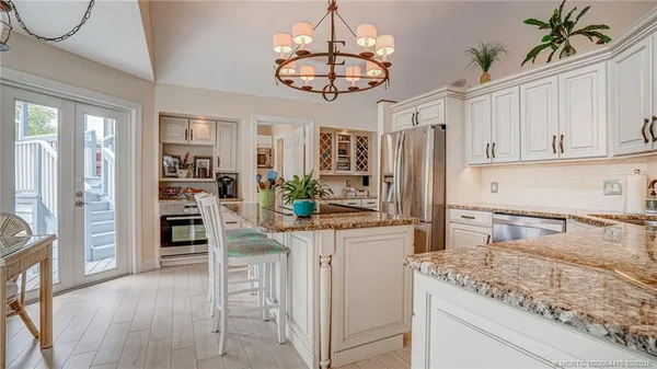 a kitchen with stainless steel appliances granite countertop a refrigerator a stove and a sink