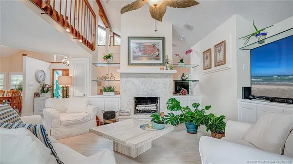 a living room with furniture a fireplace and a chandelier
