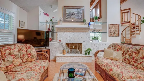 a living room with furniture a flat screen tv and a fireplace