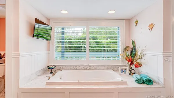 a bathroom with bathtub and window
