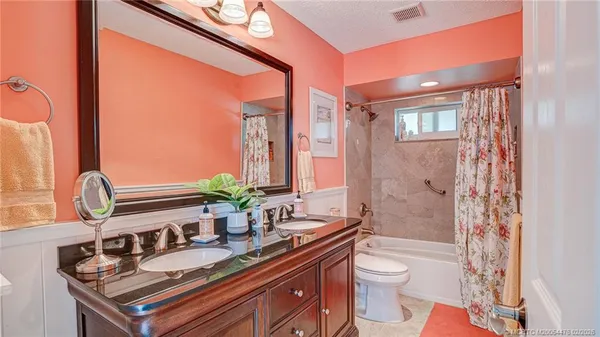 a bathroom with a double vanity sink toilet and shower
