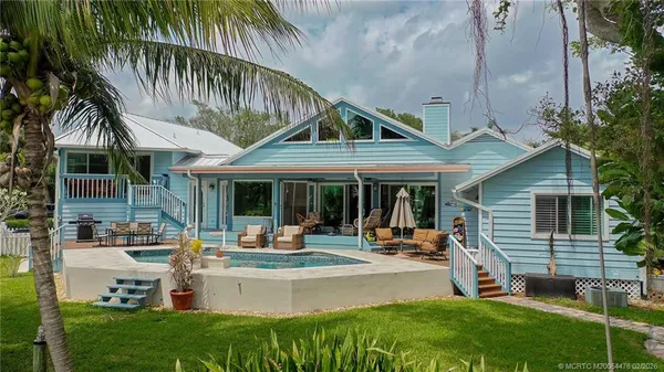 a view of a house with swimming pool and sitting area