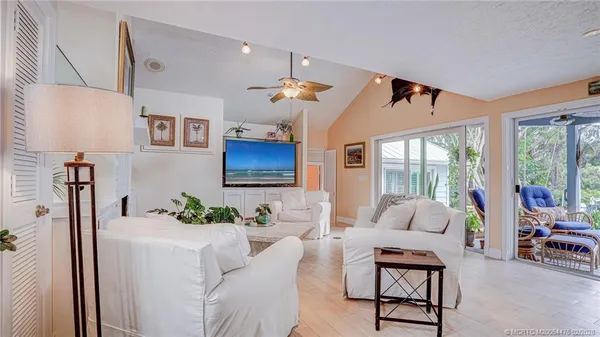 a living room with furniture a chandelier and a flat screen tv