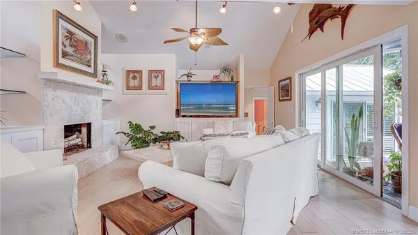a living room with furniture a chandelier and a large window
