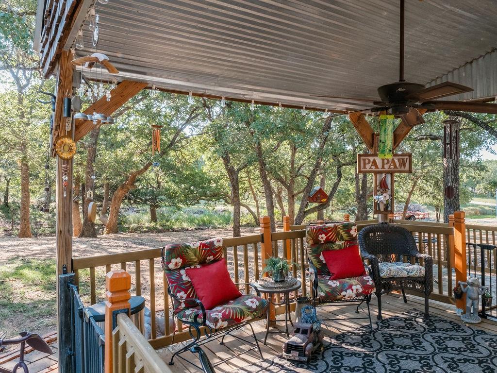 196 Perch Road Bowie, TX 76230 - Photo 28 of 33 a view of balcony with chairs and wooden floor